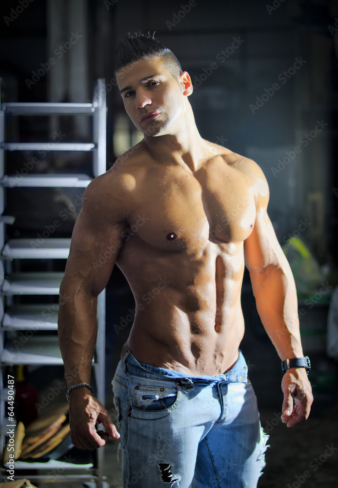 Fototapeta premium Muscular young latino man shirtless in jeans indoors