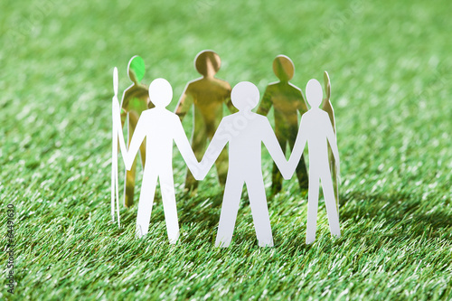 Team Of Paper People On Grassy Field photo