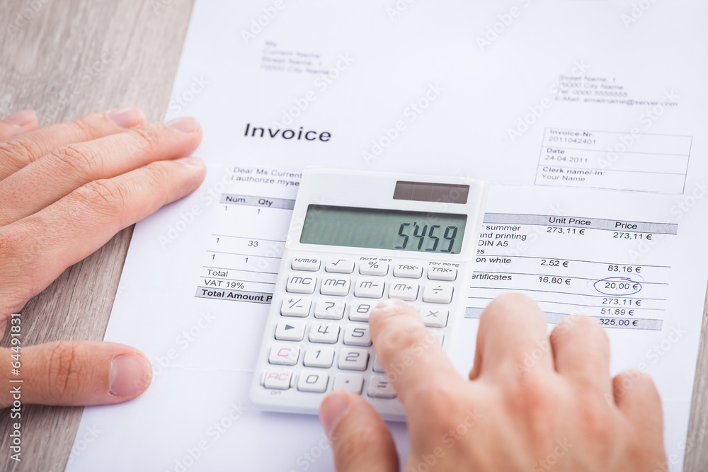 Obraz premium Businessman's Hands Calculating Invoice At Desk