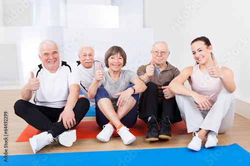 Female Trainer With Senior Customers At Gym