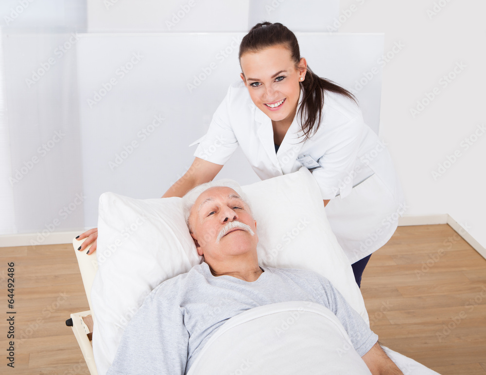 Happy Doctor With Senior Man Lying In Bed Happy Doctor With Senior Man Lying In Bed