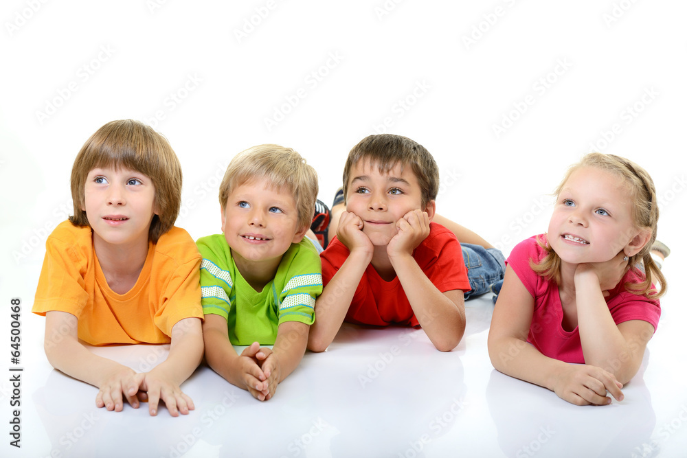 cute children in colored t-shirts lying and smiling looking with cute children in colored t-shirts lying and smiling looking with
