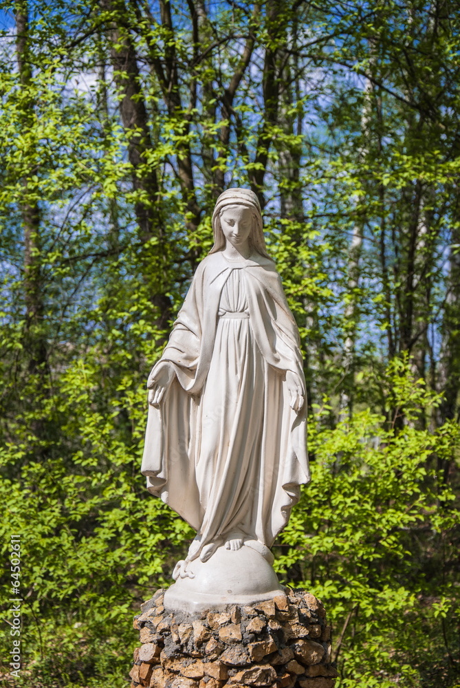 Sculpture of  Mother of God, is in  forest in holy source