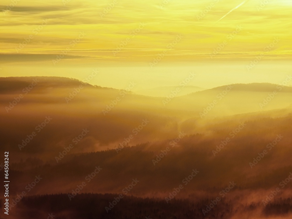 Autumn sunrise in a beautiful mountain of Bohemia. Hills in fog