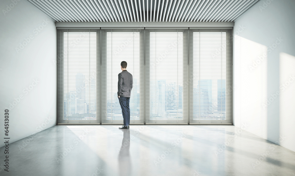 Fototapeta premium businessman looking at city through window