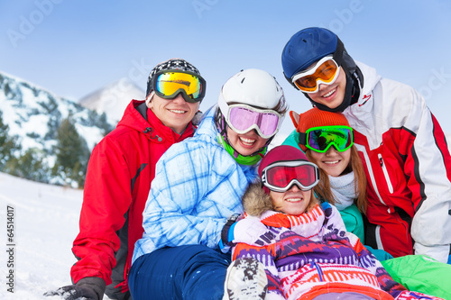 Five happy smiling friends with snowboards