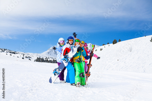 Five friends together with snowboards and skis