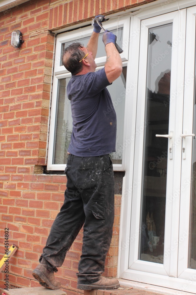 A Window fitter removing old windows in preparation for new ones A Window fitter removing old windows in preparation for new ones