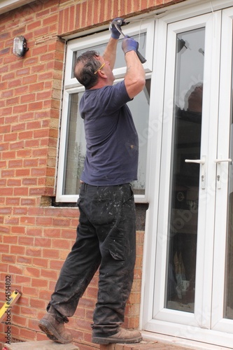 Fotografie A Window fitter removing old windows in preparation for new ones