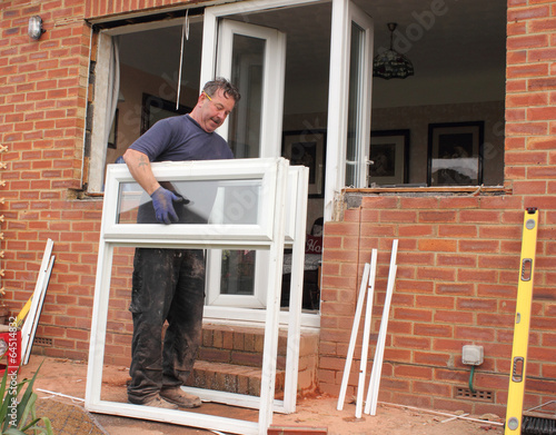 A Window fitter removing old windows in preparation for new ones