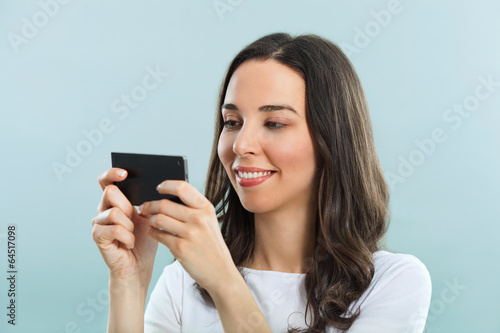 Young woman using smart phone. Studio shot.