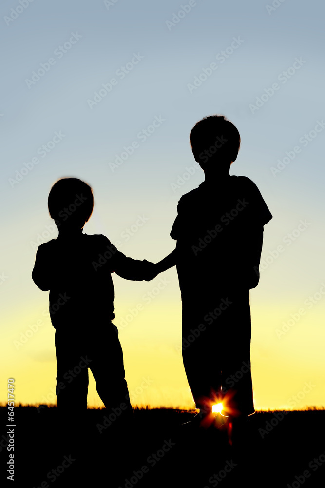 Silhouette Young Children Holding Hands at Sunset Silhouette Young Children Holding Hands at Sunset