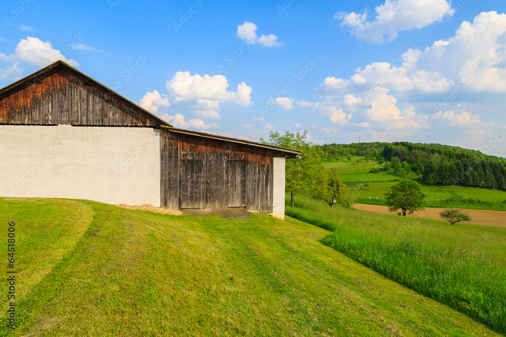 Wooden barn on farming field and blue sky, Austria
