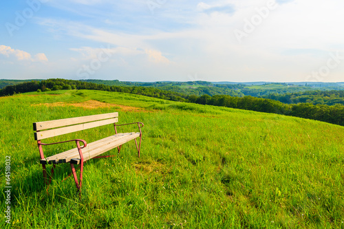 Bench on meadow in countryside landscape, Austria