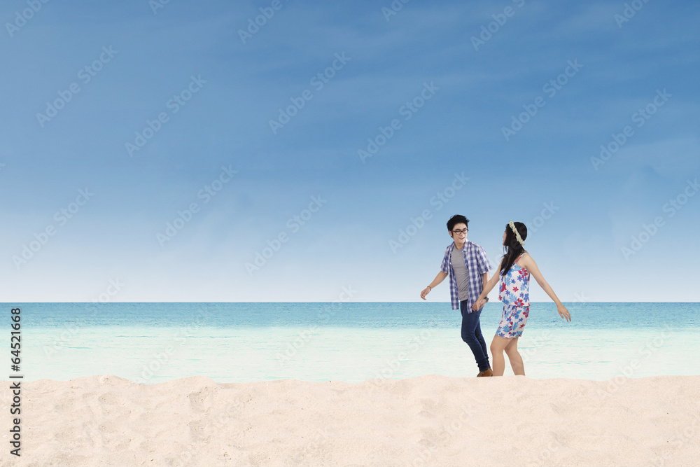 Young couple walking together on the beach