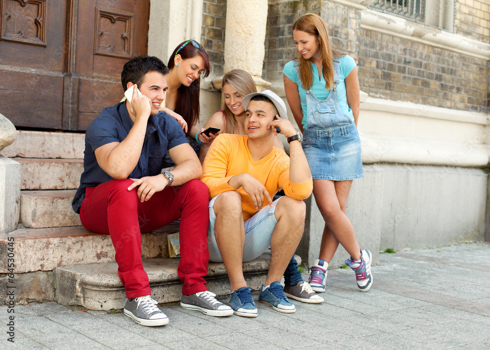 Fototapeta premium Friends using smart phones outdoors