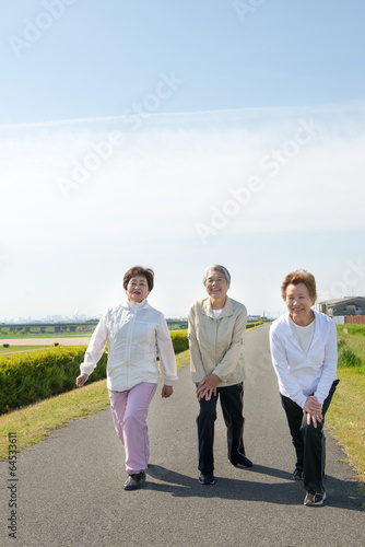 屋外でストレッチをする３人の高齢者の女性