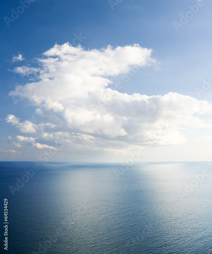blue sea and cloudy sky over it