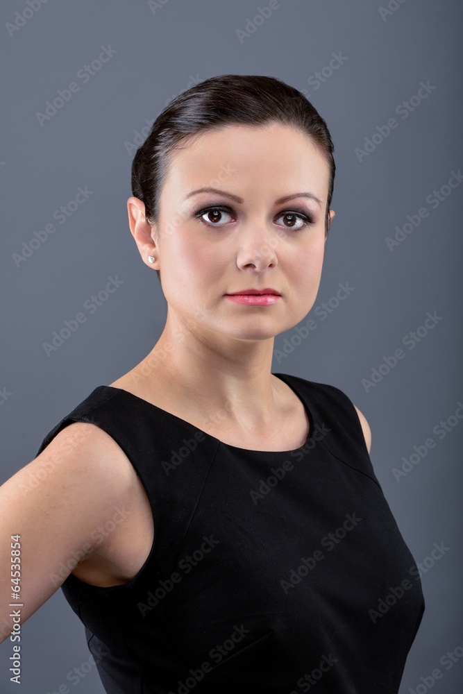 Serious woman in black dress looking into the camera Serious woman in black dress looking into the camera