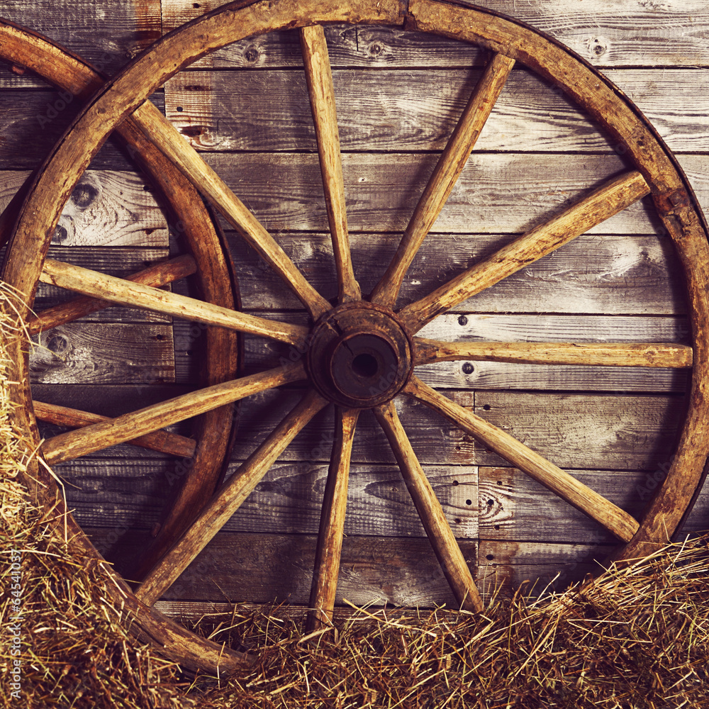 Old wooden wheel on a hay