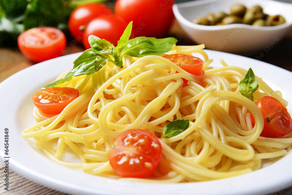 Delicious spaghetti with tomatoes on plate on table close-up Delicious spaghetti with tomatoes on plate on table close-up