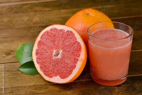 Ripe grapefruit with juice on table close-up