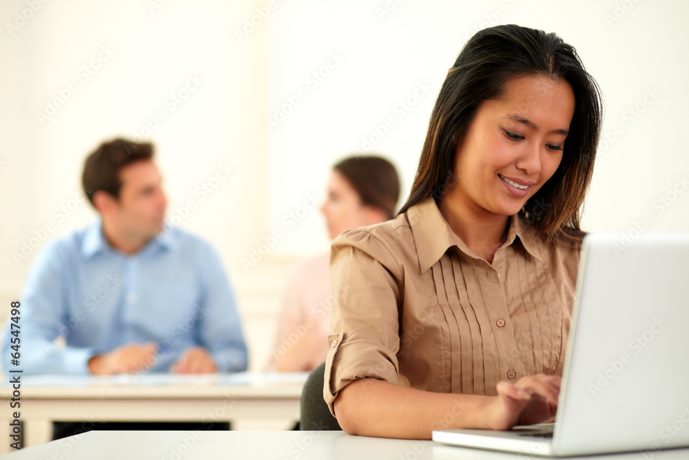 Adult asiatic woman working on her laptop Adult asiatic woman working on her laptop