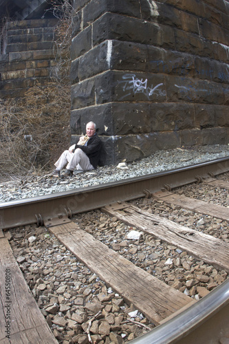 Homeless Man Living Under Railroad Bridge photo