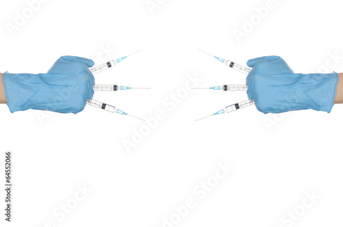 Hands in blue gloves holding several syringes