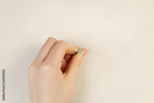 Εκτύπωση καμβά Placing nail against interior home wall