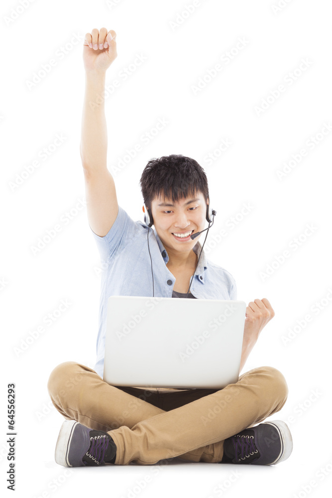 successful Young man sitting on floor and using a laptop successful Young man sitting on floor and using a laptop