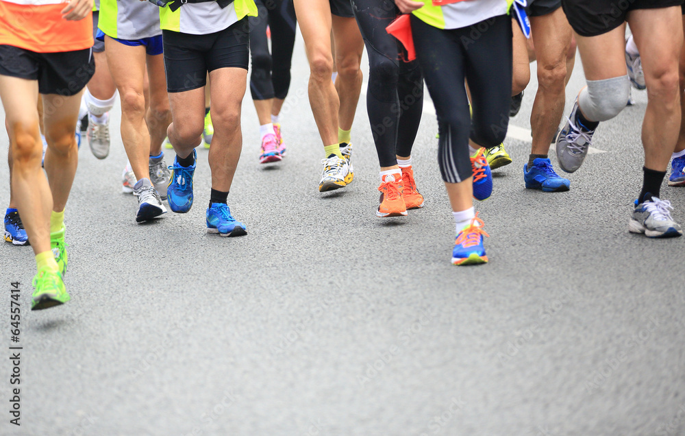 Unidentified marathon athletes legs running on street 