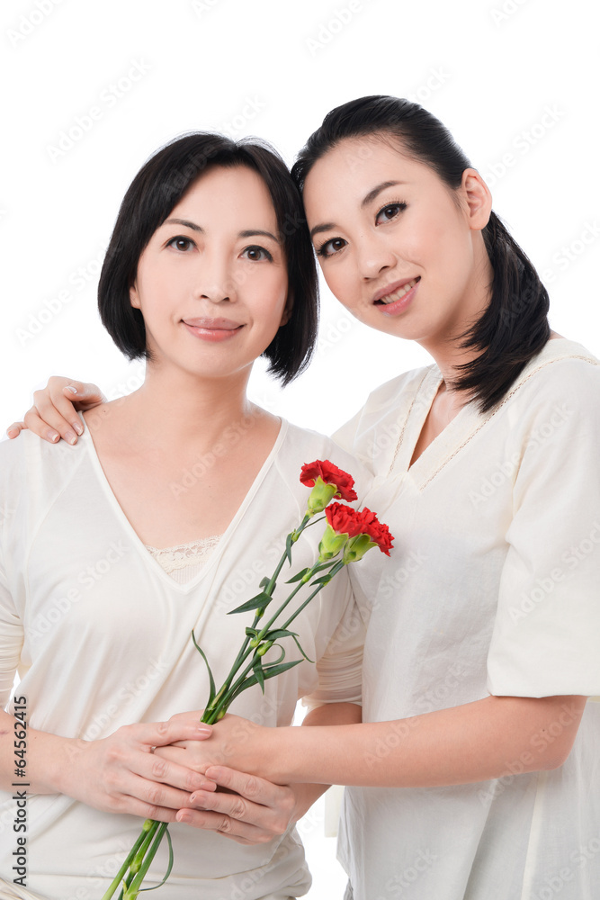 Young woman giving carnation flower to her mother