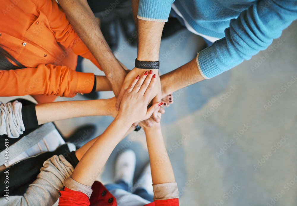 Group Of young people stacking their hands Group Of young people stacking their hands