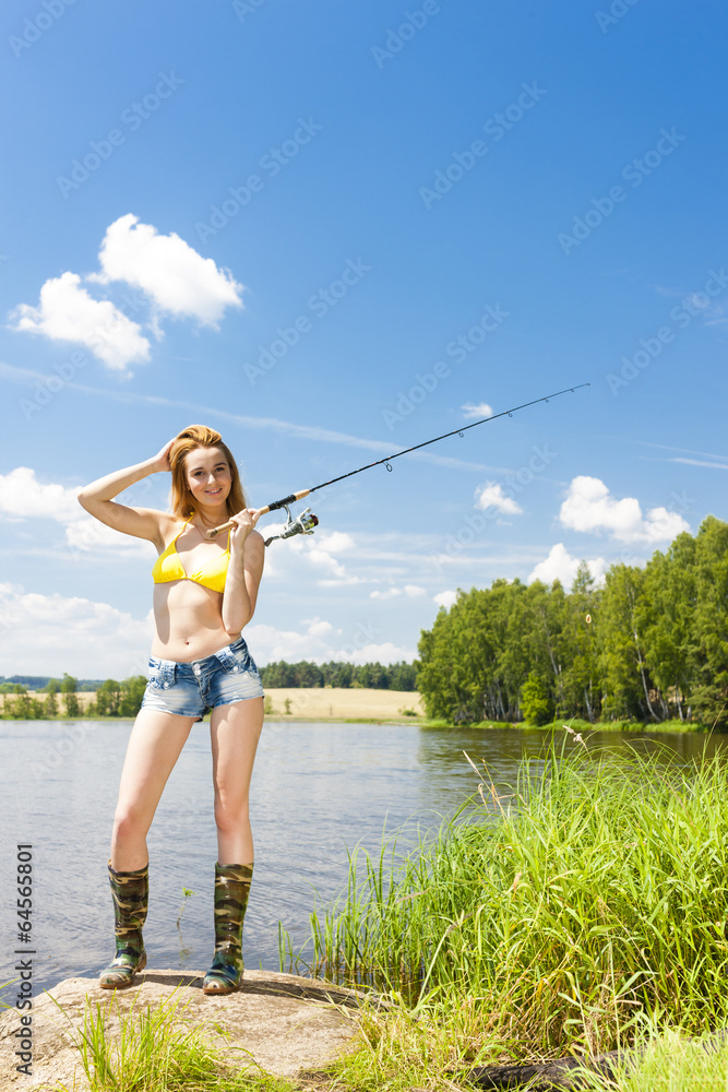 young woman fishing at pond in summer young woman fishing at pond in summer