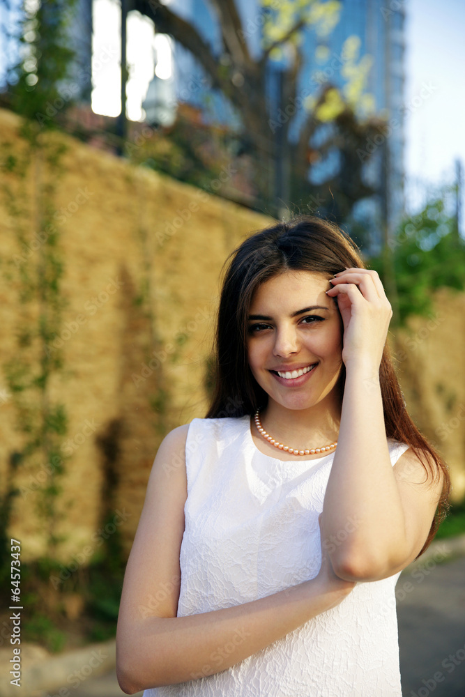 Young happy woman standing near fence Young happy woman standing near fence