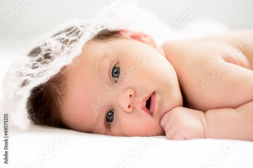 small baby girl lying on white bed