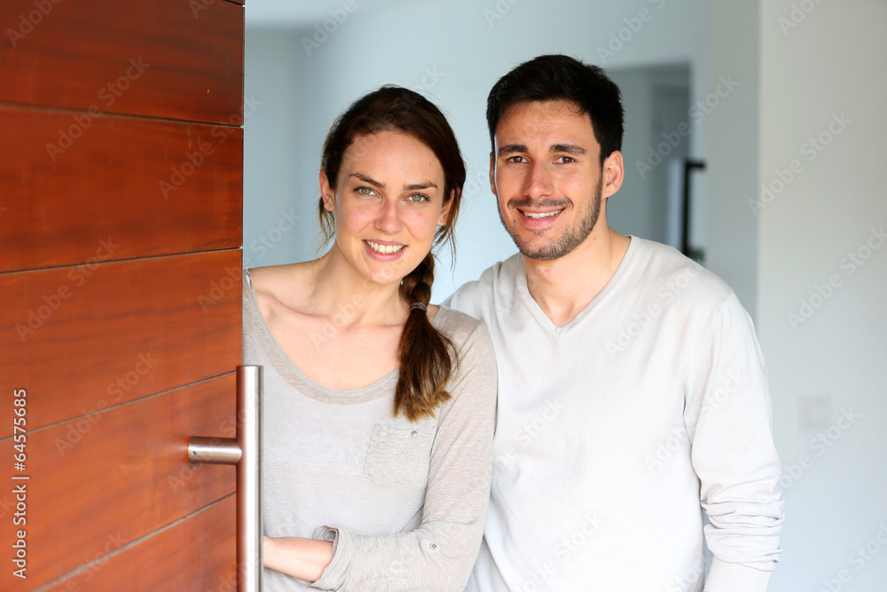 Happy couple opening new home entrance door Happy couple opening new home entrance door