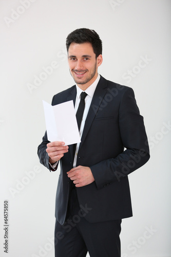 Smiling businessman holding blank flyer