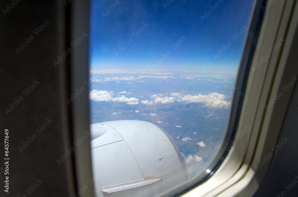 Airplane window with a view of sky and clouds. Airplane window with a view of sky and clouds.