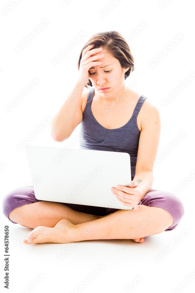 Fototapeta premium Young woman looking stressed using laptop
