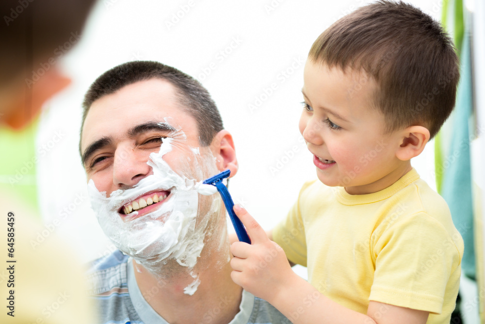 playful kid and dad shaving together at home bathroom