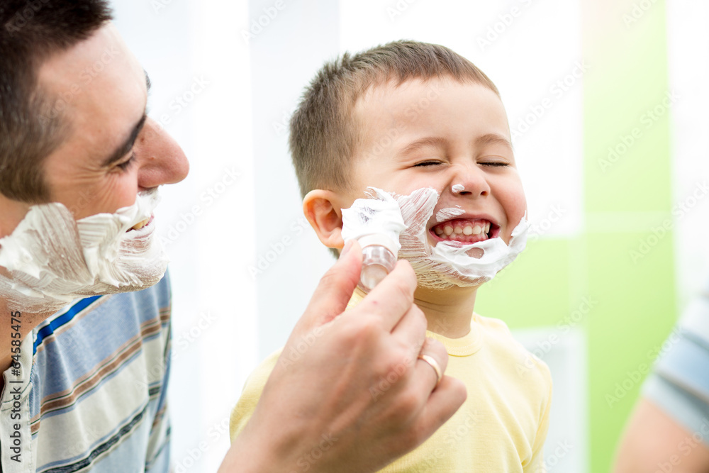 playful kid and father shaving together at home bathroom