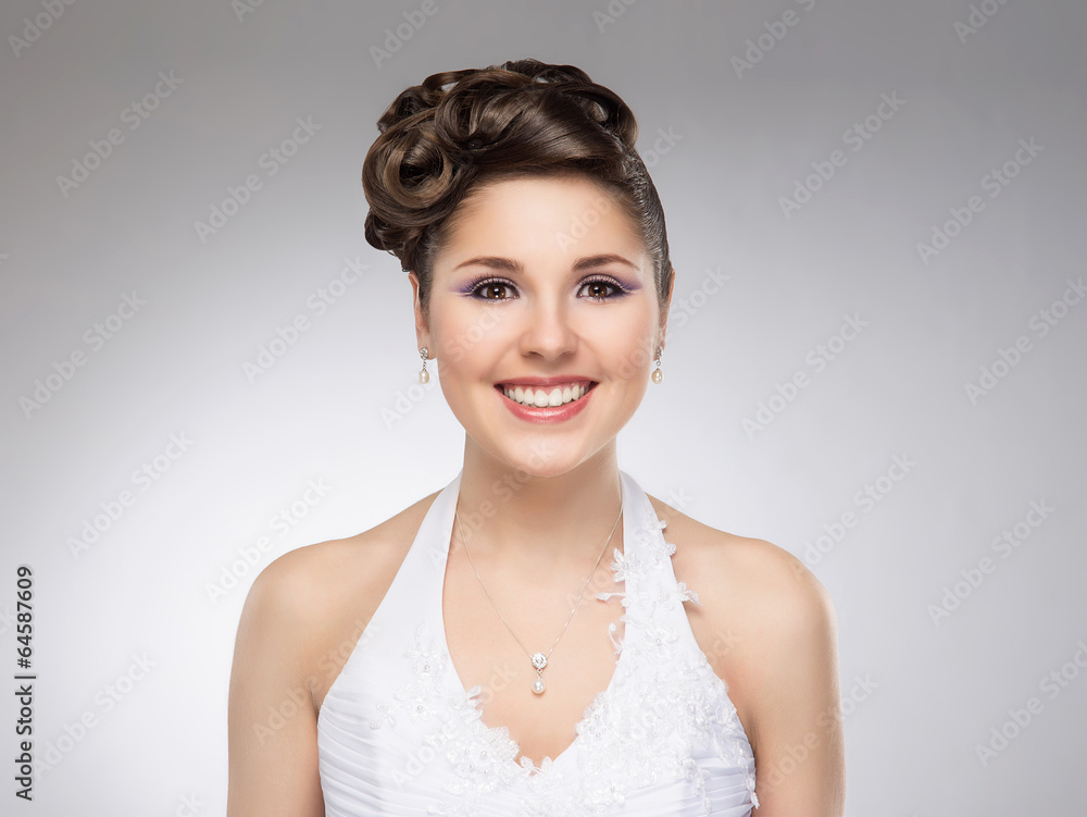 Young and beautiful bride on a grey background