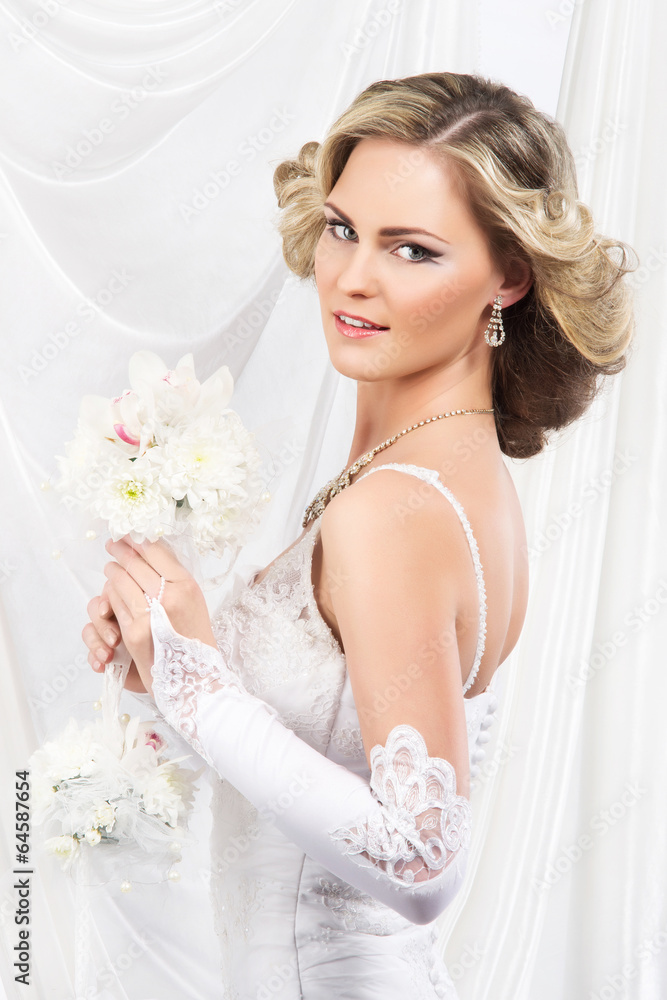 Young and beautiful bride standing with the flower bouquet over Young and beautiful bride standing with the flower bouquet over