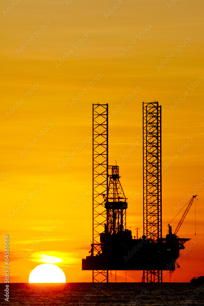 Silhouette of an offshore drilling rig at sunset