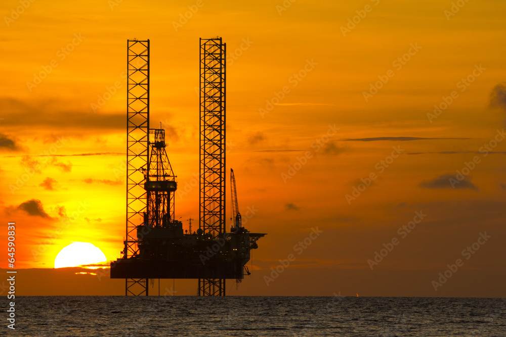 Silhouette of an offshore oil rig at sunset