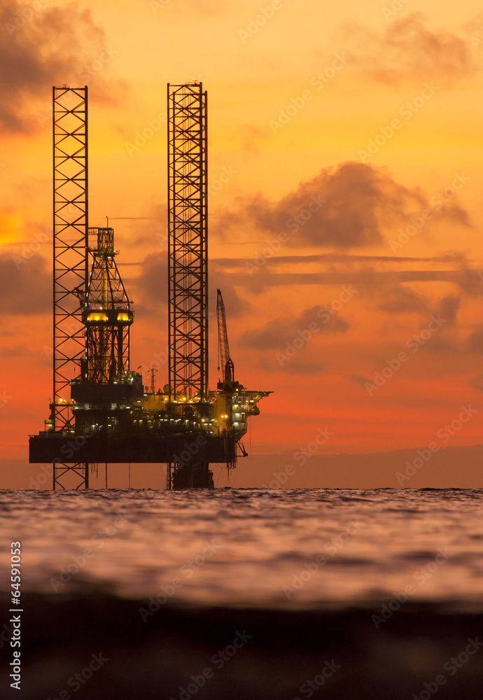 Naklejka premium Silhouette of an offshore oil rig at sunset