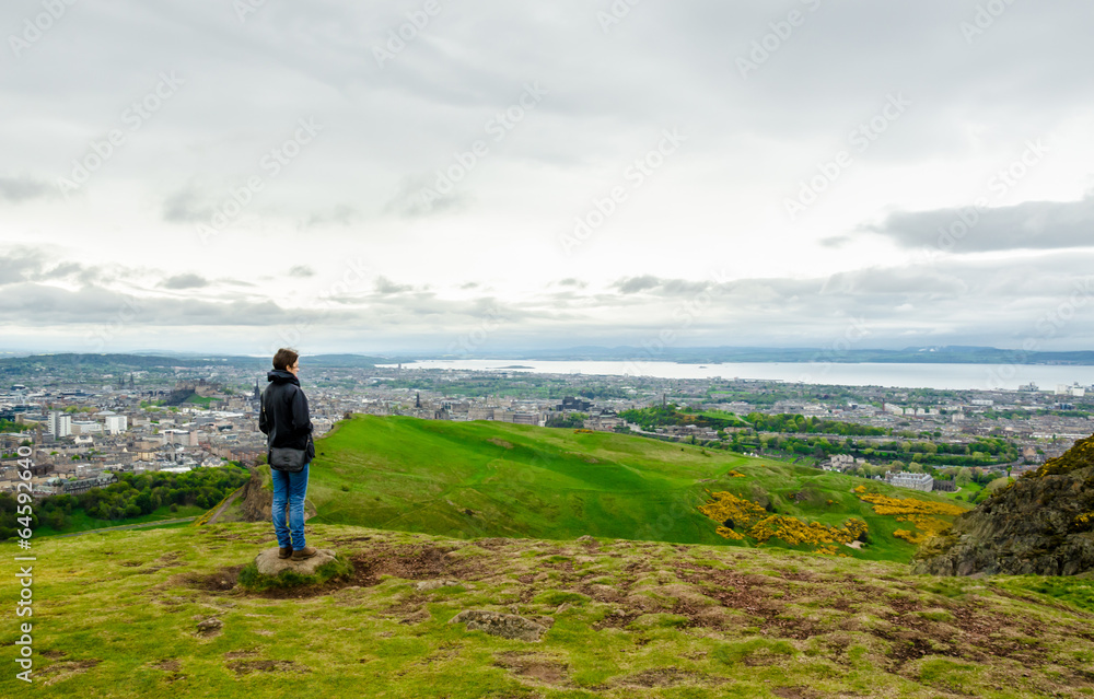 Young female model admiring Edinburgh landscape from the top of