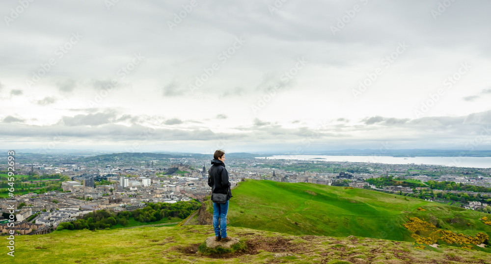 Young female model admiring Edinburgh landscape from the top of